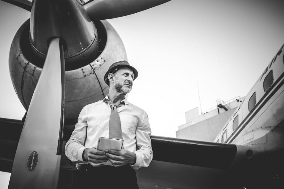 Roman Freud in a hat beside an airplane propeller